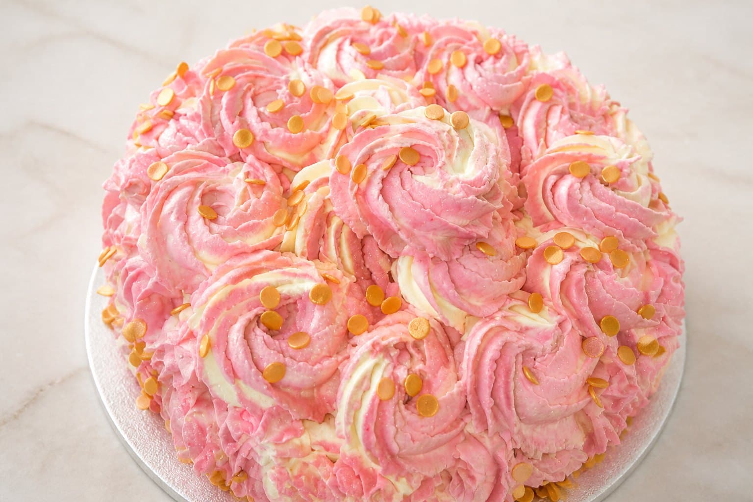 Round pink and cream rosette cake with gold sequins