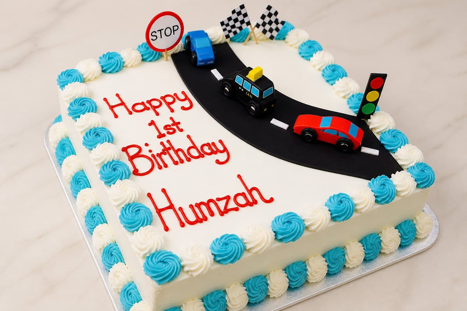 First birthday cake with a racing theme, toy cars and blue rosettes